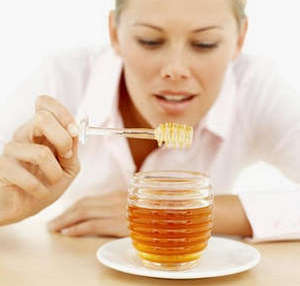 Девушка ест мед