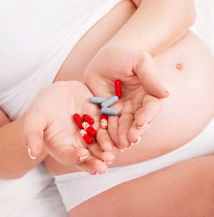 Беременная держит таблетки в руках