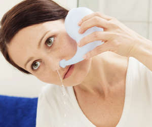 Женщина промывает нос