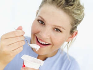 Девушка ест йогурт