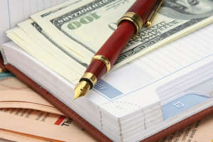 Деньги и ручка в блокноте