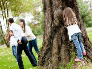 Девочка спряталась за деревом
