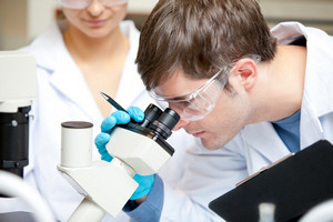 Ученый смотрит в микроскоп