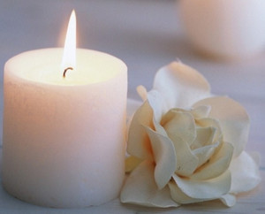 Бутон белой розы и горящая свеча