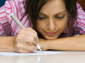 Девушка пишет на листе бумаги