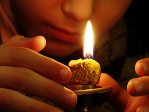 Девушка смотрит как горит свеча