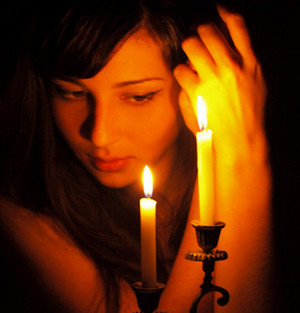 Девушка смотрит на пламя свечи
