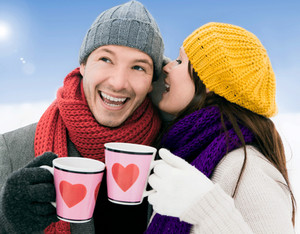 Мужчина и женщина в зимней одежде держат кружки