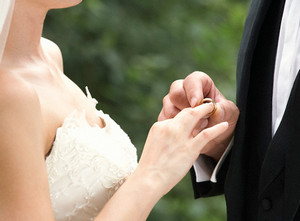 Мужчина одевает кольцо на палец женщине