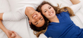 Счастливые муж и жена лежат в кровати