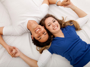 Счастливые муж и жена лежат в кровати