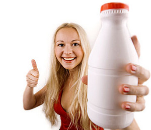 Девушка держит в руках бутылку кефира
