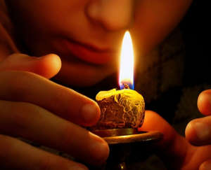 Девушка смотрит как догорает свеча