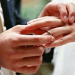 Муж одевает кольцо на палец жене