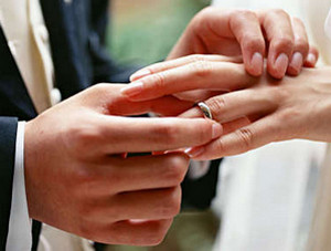 Муж одевает кольцо на палец жене
