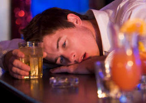Пьяный молодой человек со стаканом в руке