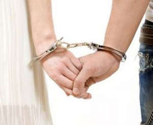 Руки мужчины и женщины скованы наручниками