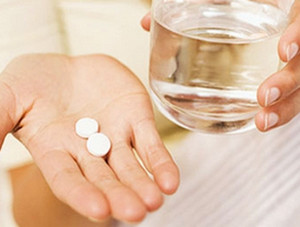 Две таблетки на ладони и стакан воды
