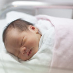 Новорожденная девочка под розовым одеялом