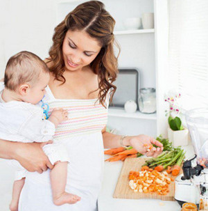 Девушка режет овощи с ребенком на руках