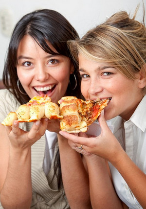 Две девушки едят пиццу