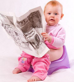 Ребенок сидит с газетой в руках