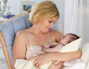 Женщина держит на руках своего новорожденного