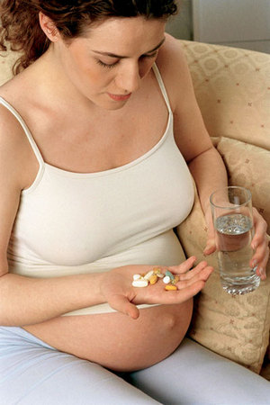 Беременная пьет таблетки