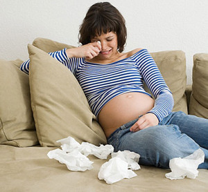 Беременная девушка в полосатой кофте плачет