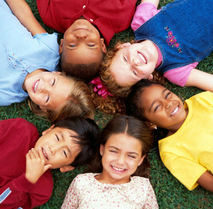 Дети разных национальностей лежат на траве