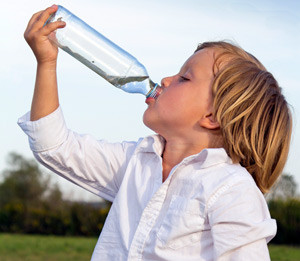 Мальчик пьет раствор Регидрона из бутылки
