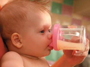 Малыш пьет сок из детской бутылочки