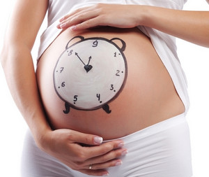 Нарисованные часы на животе беременной девушки