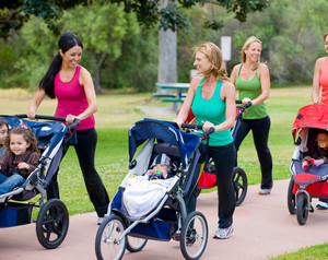Женщины гуляют с колясками по парку