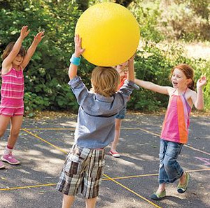 Дошкольники играют большим желтым мячом