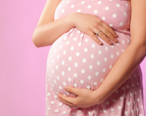 Розовое в белый горошек платье на беременной девушке