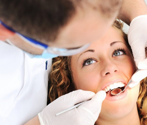 Стоматолог осматривает зубы