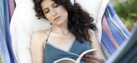 Женщина читает книгу в гамаке