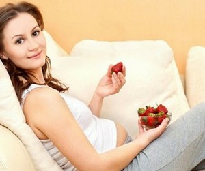 Беременная женщина ест клубнику