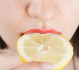 Девушка ест лимон