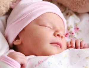 Новорожденный ребенок в розовой шапочке