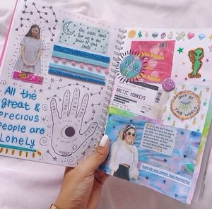 Дневник с картинками в руке девочки