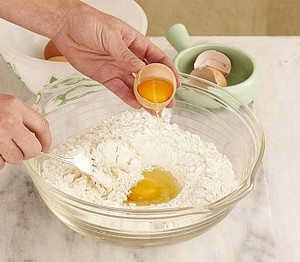 Добавление яиц в тесто для блинов