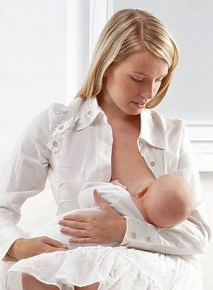 Девушка кормит ребенка грудью