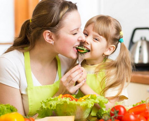 Мама и дочка едят овощи