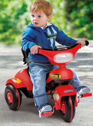 Мальчик на красном трехколесном велосипеде