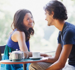 Парень и девушка ведут веселую беседу за столиком в кафе
