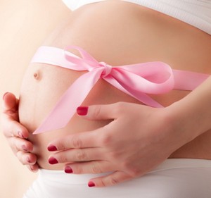 Розовый бантик на животе беременной женщины
