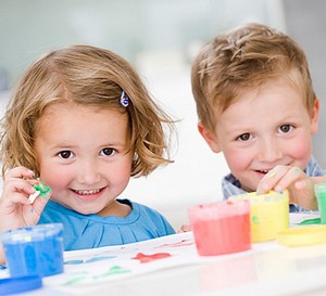 Трехлетние мальчик и девочка рисуют красками