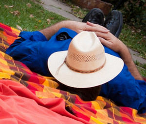 Испанский мужчина спит на траве на пледе